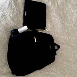 Tumi travel bag (book bag type) with pouch and can slide over roller bag handles